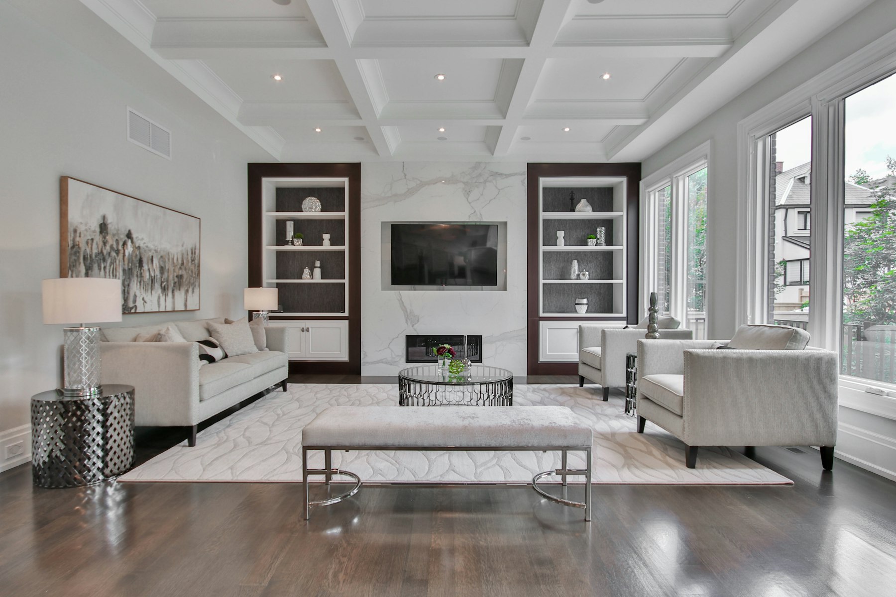 Double-height living room with pale stone floors and tall glass
